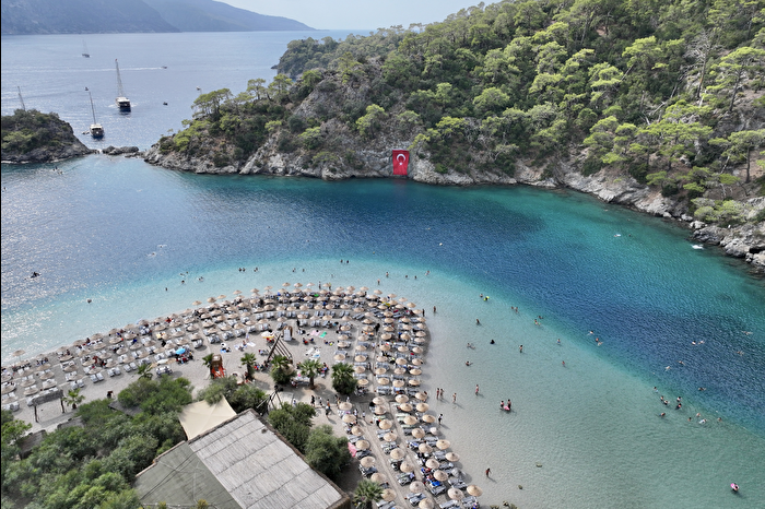 Güneşli havanın devam ettiği Fethiye ve Marmaris'te sahillerde deniz keyfi sürüyor